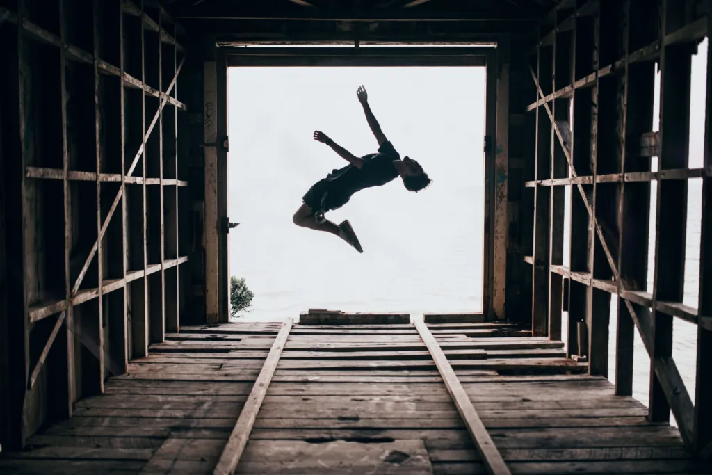 Man jumping over backwards. Photo by Liam Shaw on Unsplash